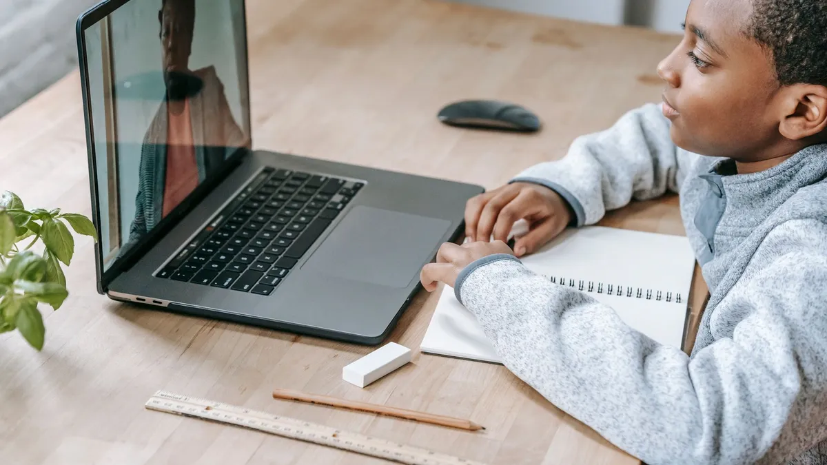 Dizüstü bilgisayar başında ders çalışan çocuk; online çocuk psikolojik desteği